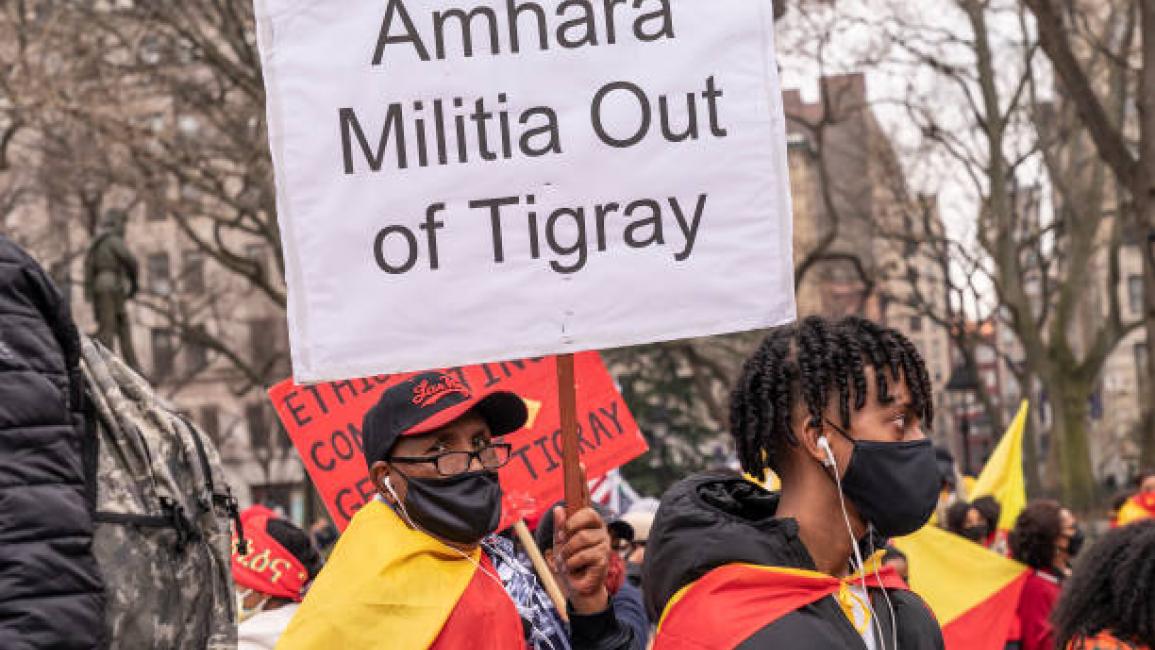 	NEW YORK, UNITED STATES - 2021/03/26: Protesters with Tigray flags and posters staged rally on Washington Square and walk along Broadway demanding end of Ethiopia offence on civilians. Conflict between Tigray Regional Government and Ethiopian Government started in 2019 and escalated into an open war on November 4, 2020. More than 2.3 million children are cut off from desperately needed aid and humanitarian assistance. Many protesters were wearing jackets, hat and facial masks in colors of Tigray flag. (Pho