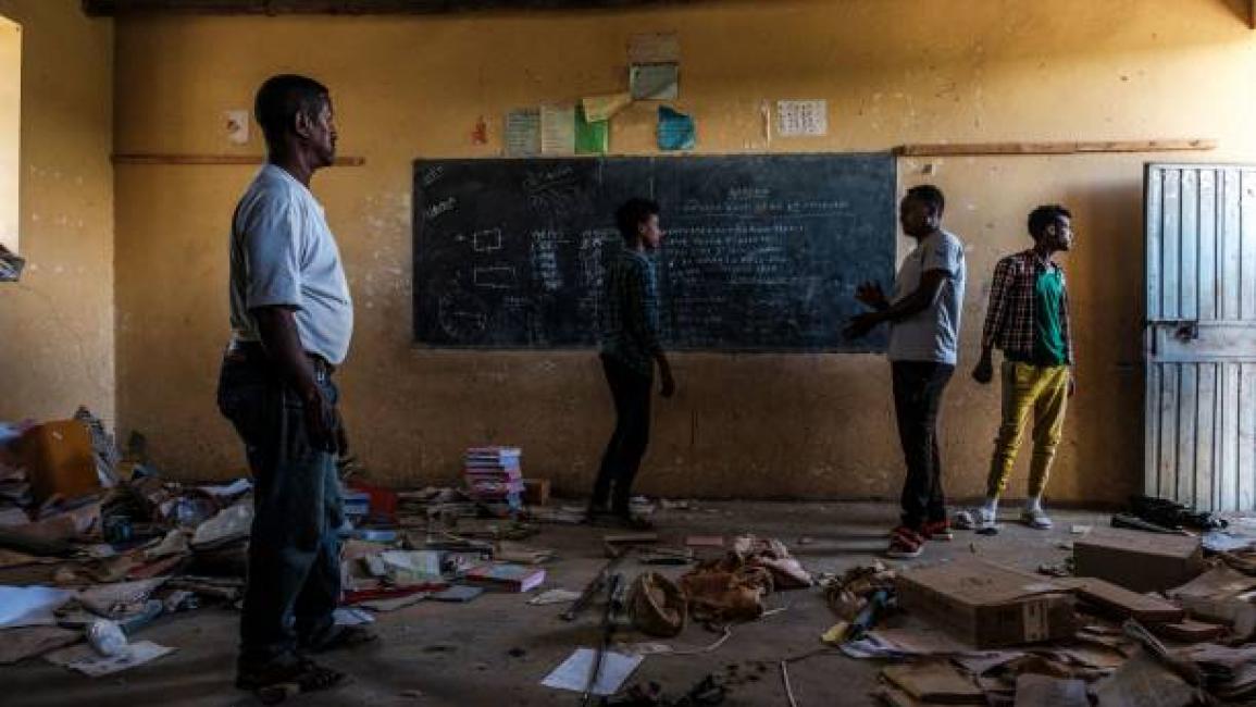 	People stand in a looted classroom at Ksanet Junior Secondary School, which was shelled as federal-aligned forces entered the city and looted allegedly by Eritrean forces, in Wukro, north of Mekele, on March 1, 2021. - Every phase of the four-month-old conflict in Tigray has brought suffering to Wukro, a fast-growing transport hub once best-known for its religious and archaeological sites. Ahead of federal forces' arrival in late November 2020, heavy shelling levelled homes and businesses and sent plumes o