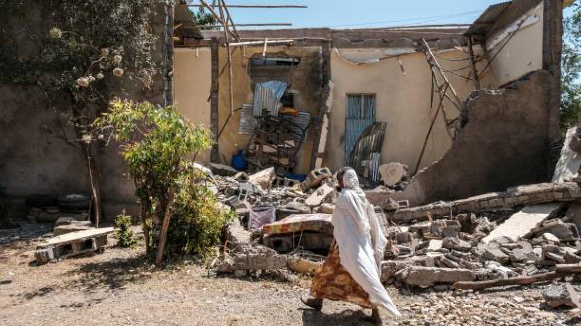 	A woman walks in front of a damaged house which was shelled as federal-aligned forces entered the city, in Wukro, north of Mekele, on March 1, 2021. - Every phase of the four-month-old conflict in Tigray has brought suffering to Wukro, a fast-growing transport hub once best-known for its religious and archaeological sites. Ahead of federal forces' arrival in late November 2020, heavy shelling levelled homes and businesses and sent plumes of dust and smoke rising above near-deserted streets. Since then the 