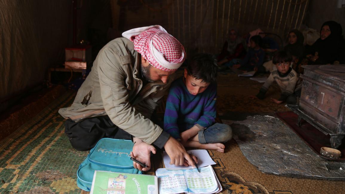 يعلّم ابنه في إدلب (عارف تمّاواي/ فرانس برس)