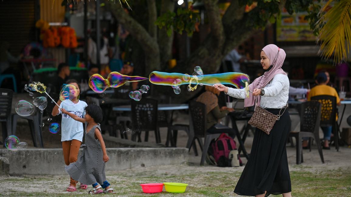 تمضي وقتاً لطيفاً مع أولادها في ماليزيا (محمد رسفان/ فرانس برس)