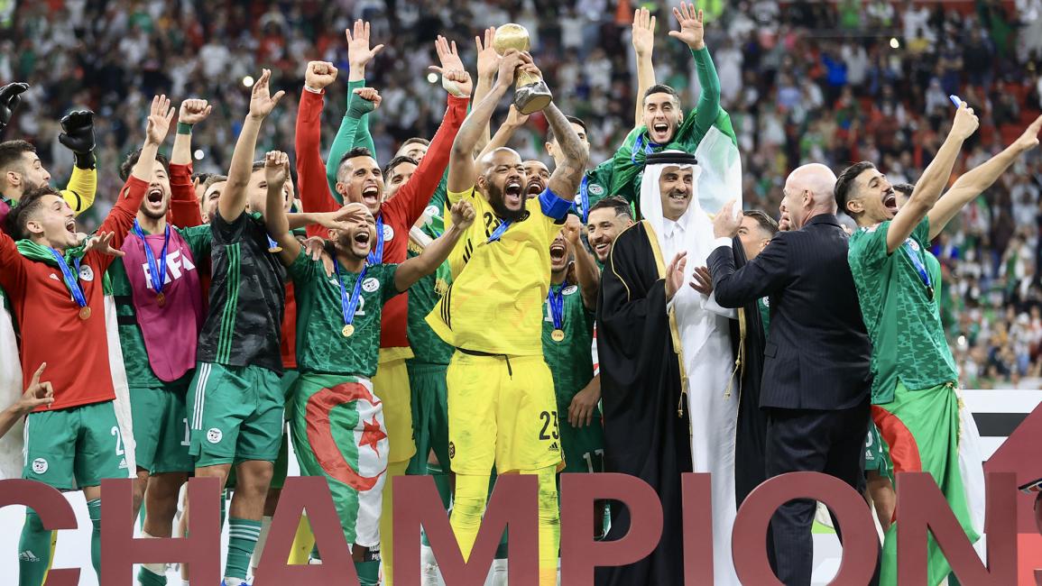 لحظة تسليم كأس العرب لعميد منتخب الجزائر (محمد دبوس/الأناضول)