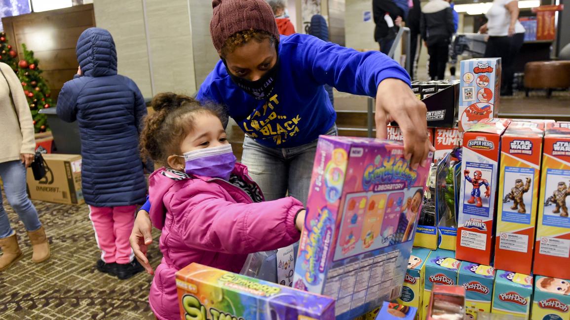  متطوعة تساعد طفلة في اختيار هدية في بنسلفانيا (بن هاستي/ Getty)