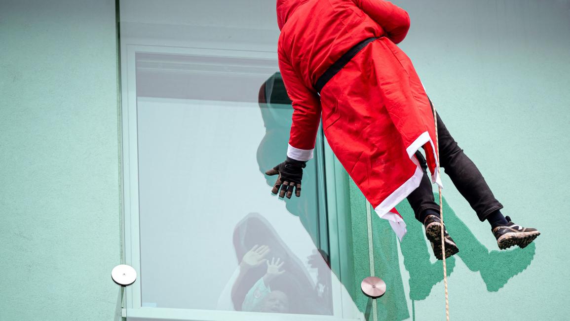 لحظات بهجة لأطفال مع بابا نويل نزل من الأعلى في سلوفينيا (أورلاندو ايسترادا/ فرانس برس)