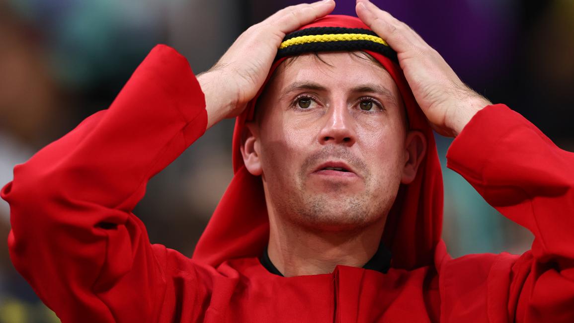 مشجع بلجيكي يعدّل غطاء رأسه الأحمر خلال مباراة بلجيكا وكندا (روبي جاي بارات/ Getty)