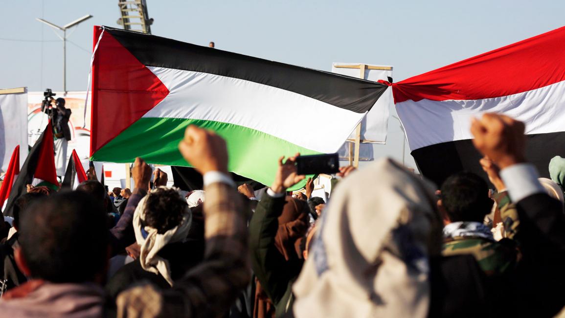يمنيون يرفعون العلم الفلسطيني واليمني (محمد حمود/Getty)