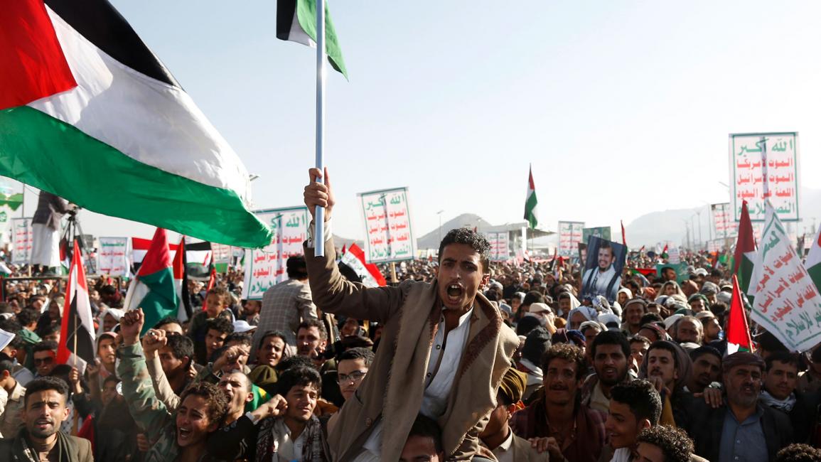 يمنيون يرفعون لافتات تصور زعيم حركة الحوثيين (أنصار الله) عبد الملك بدر الدين الحوثي (محمد حمود/Getty)