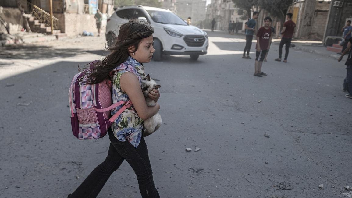 فتاة فلسطينية تحمل قطة في مدينة غزة (علي جاد الله/ Getty)