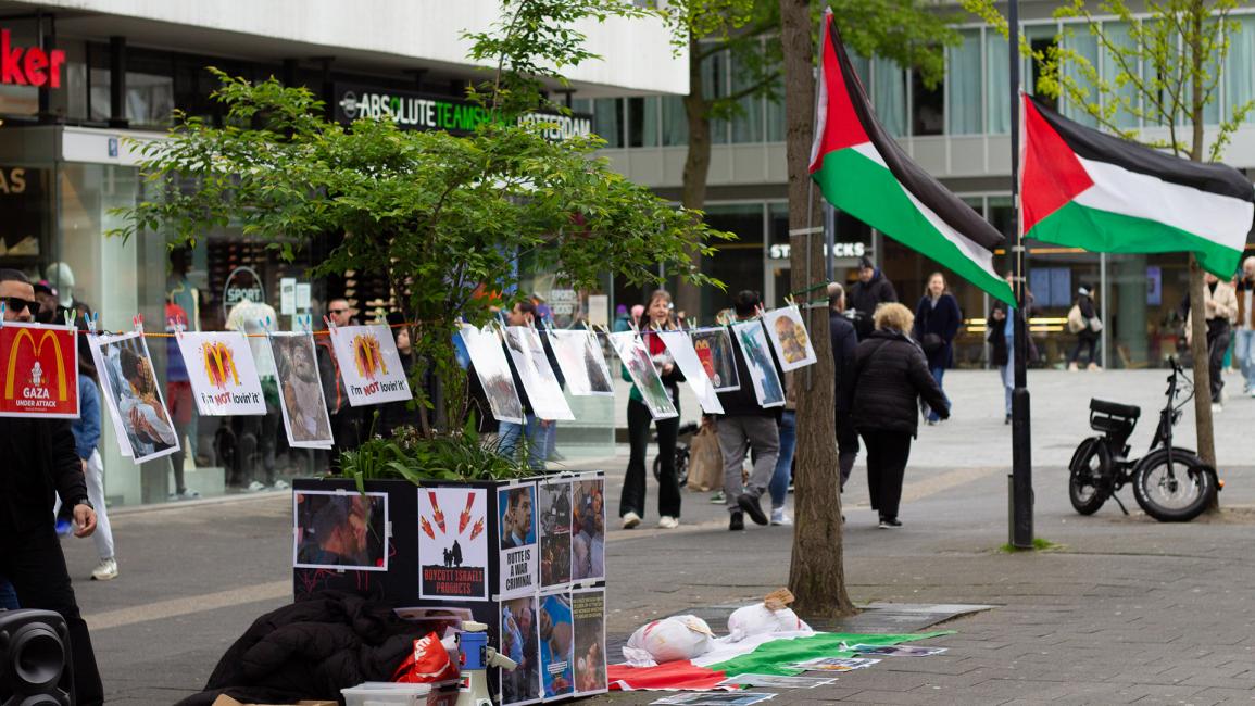 علق المتظاهرون الأعلام الفلسطينية أمام الفرع  (عبد الله عاشران/الاناضول)