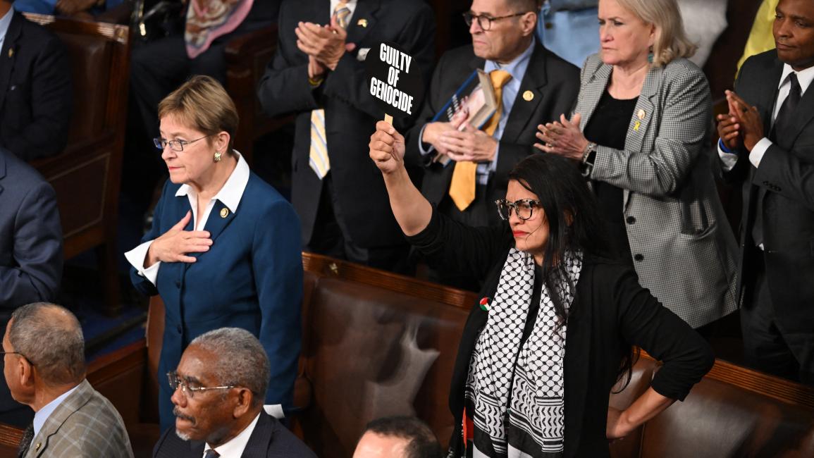 النائبة رشيدة طليب تحمل لافتة تقول "مجرم حرب" أثناء حضورها خطاب نتنياهو أمام الكونغرس ( 24/7/2024 Getty)