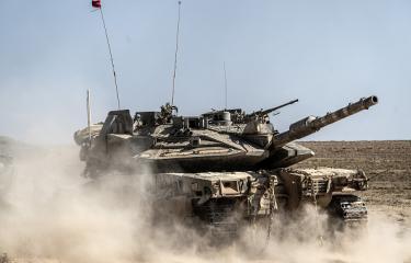 دبابة إسرائيلية معطوبة أثناء نقلها من قطاع غزة، 9 يوليو 2024 (مصطفى الخاروف/الأناضول)