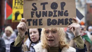 "أوقفوا تمويل الأسلحة" لافتة خلال تظاهرة في واشنطن تضامناً مع غزة 27/2/2024 (مصطفى باسم/الأناضول)