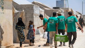 توزيع مساعدات في مخيم بإدلب العام الماضي (رامي السيد/ Getty)