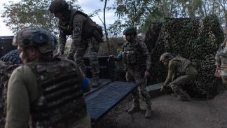جنود أوكرانيون يفرغون قذائف هاون من شاحنة صغيرة، 31 يوليو 2024 (الأناضول)