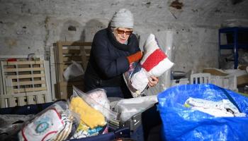 متطوع يفرز ملابس تم التبرع بها لدعم الفقراء في لندن (دانيال ليل/فرانس برس)