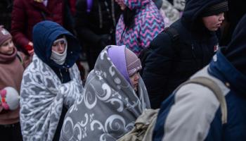 لاجئون عند الحدود بين أوكرانيا وبولندا وسط البرد (الأناضول)