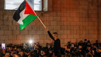 رفع العلم الفلسطيني في مدينة حيفا أثناء مظاهرة تضامنية مع معتقلي هبة الكرامة (أحمد غرابلي/فرانس برس)