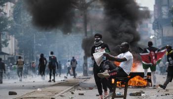 متظاهر يقرأ صحيفة خلال مظاهرة مناهضة للحكومة وسط نيروبي ( 2/ 7/ 2024 فرانس برس) 