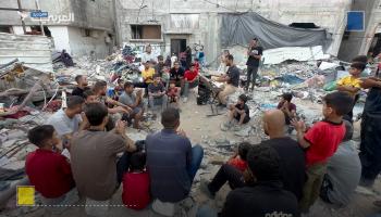 عائلة فلسطينية تنشد فوق ركام المنازل في قطاع غزة 