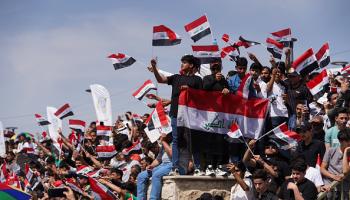 يحملون الأعلام العراقية بفعاليات عيد الربيع بالموصل، إبريل (Getty)