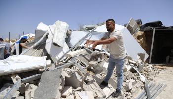 فلسطيني فوق أنقاض منازل هدمها الاحتلال في قرية بيرين بالخليل، 04 يوليو 2024 (الأناضول)