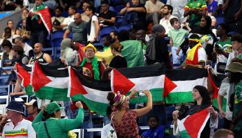 مشجعون يرفعون أعلام فلسطين خلال مباراة مالي وإسرائيل  في بارك دي برينس في 24 يوليو 2024 في باريس (ماجا هيتيج/Getty)