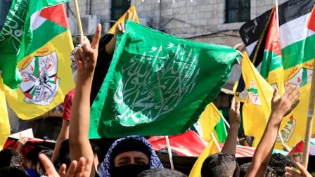 فلسطينيون يرفعون رايات حماس وفتح في نابلس، 26 أكتوبر 2023 (Getty)