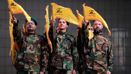 عناصر من حزب الله يرفعون شعاره، 4 نوفمبر 2023 (فرانس برس)