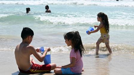 أطفال يلعبون على شاطئ صور، 28 يوليو/تموز 2024 (حسام شبارو/ الأناضول)