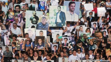 رفع صور لضحايا في تفجير مرفأ بيروت 4 أغسطس 2024 (العربي الجديد)