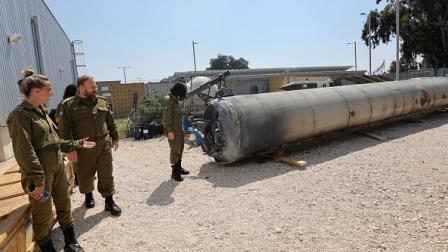 جنود إسرائيليون قرب بقايا صاروخ إيراني خلال هجوم إبريل 2024 (جيل كوهين ماغن/فرانس برس)