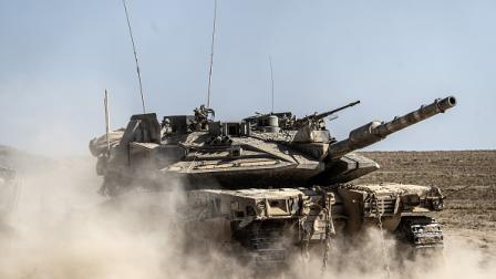 دبابة إسرائيلية معطوبة أثناء نقلها من قطاع غزة، 9 يوليو 2024 (مصطفى الخاروف/الأناضول)